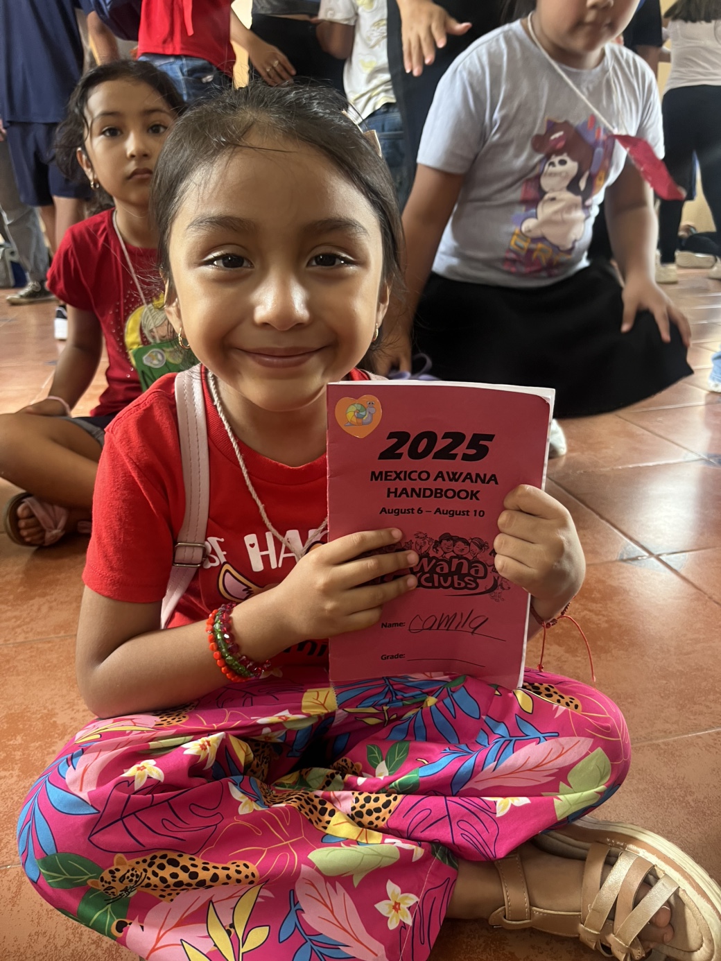 Child with 2025 Mexico Awana handbook